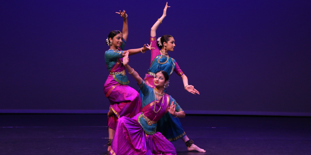 Sampradaya dancers on a stage in colourful costumes